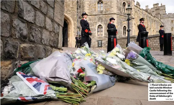  ?? Leon Neal ?? > Floral tributes are laid outside Windsor Castle following the announceme­nt of the Duke of Edinburgh’s death