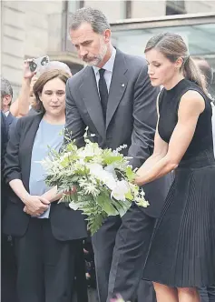  ??  ?? King Felipe VI and Queen Letizia lay a wreath of flowers for the victims of the Barcelona attack on Las Ramblas boulevard next to Barcelona’s mayor Ada Colau. — AFP photo