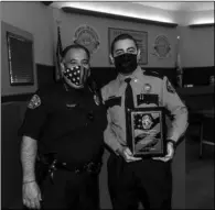  ?? PHOTO VINCENT OSUNA ?? Calexico Police explorer captain Exon Luna (sixth from right) holds his honorary plaque while posing alongside his fellow explorers and Calexico Police Department personnel during the Calexico City Council meeting on Wednesday.