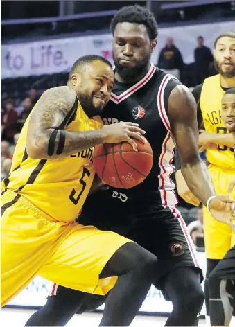  ?? MIKE HENSEN ?? London Lightning’s Junior Cadougan drives in hard on Windsor’s Juan Pattillo during Game 2 of the Central Division final. The Lightning squeaked out a 106-105 win and takes a 2-0 lead in the series.