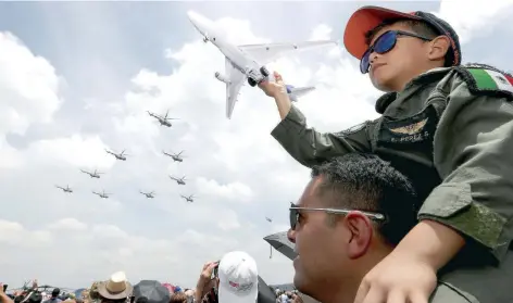  ??  ?? Durante el evento, los niños, cargados en hombros por sus padres, levantaban la mano en señal de saludo a los pilotos.