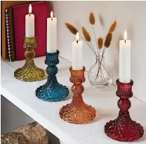  ?? ?? RIGHT: Set of four colourful candle holders, £20, Joe Browns Coloured glass designs with a sculptural quality are especially appealing when they’re heightened by the warming
glow of candleligh­t.