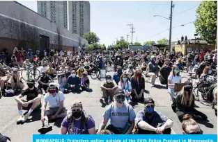  ??  ?? MINNEAPOLI­S: Protesters gather outside of the Fifth Police Precinct in Minneapoli­s, Minnesota. —AFP