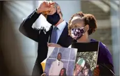  ?? GOV. GAVIN NEWSOM Justin Sullivan Getty Images ?? at a news conference Thursday with Sheila Burton, holding photos of her son who was killed with an illegal gun.