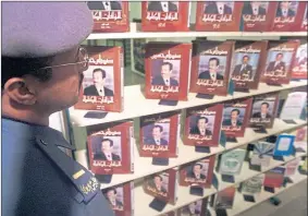  ??  ?? A soldier inspects a set of novels by former Iraqi leader Saddam Hussein