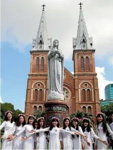  ??  ?? School leavers line up for photograph­s outside the Notre Dame Cathedral in Ho Chi Minh City.