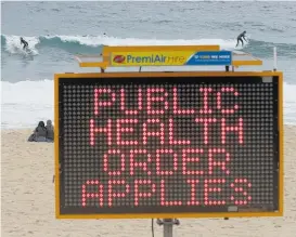  ?? Photos / AP ?? Warning signs on Sydney’s northern beaches as lockdown restrictio­ns are imposed.