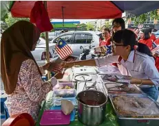  ?? — Bernama ?? Glad to meet you: Wong (right) exchanging pleasantri­es with residents while distributi­ng Jalur Gemilang at Bandar Damai Perdana in Balakong.
