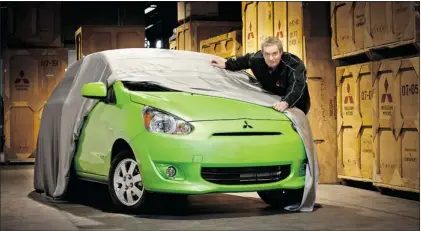  ?? COURTESY OF MITSUBISHI MOTOR SALES OF CANADA ?? Peter Renz, national marketing director for Mitsubishi Motor Sales of Canada, in this teaser photo, offers a peek at the 2014 Mitsubishi Mirage which gets its North American debut at the Montreal Internatio­nal Auto Show.