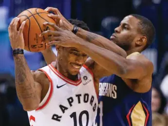  ?? RICK MADONIK/TORONTO STAR ?? Raptor high scorer DeMar DeRozan hangs on under pressure from Darius Miller of the Pelicans at the ACC.