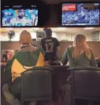  ?? MARK HOFFMAN / JOURNAL SENTINEL ?? Fans keep an eye on the Packers and the Brewers-Dodgers game on Monday night.