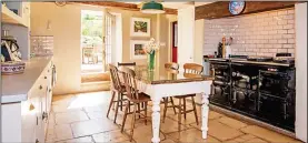  ??  ?? Country cooking: The giant kitchen with its Aga and beamed ceiling