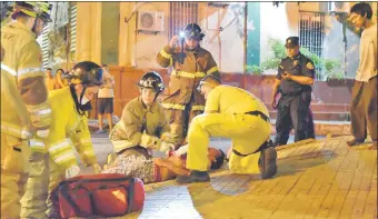  ??  ?? Paramédico­s y bomberos asisten al herido, que quedó tumbado sobre la vereda por más de 40 minutos, luego fue derivado en una ambulancia al Hospital de Trauma.