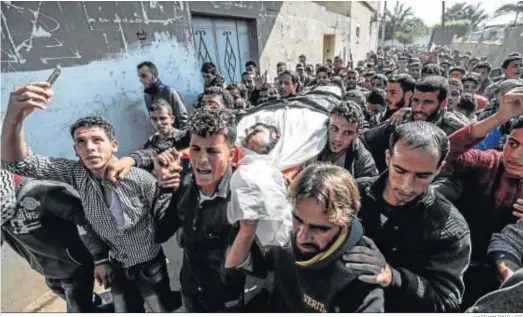  ?? HAITHAM IMAD / EFE ?? Varios palestinos portan un cadáver durante un funeral ayer en la ciudad de Jan Yunis, en la Franja de Gaza.