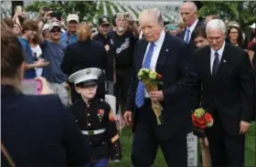  ?? WASHINGTON POST PHOTO BY MATT MCCLAIN ?? Christian Jacobs, 6, left, President Donald Trump and Vice President Mike Pence visit Arlington National Cemetery on Monday in Arlington, Va., in observance of Memorial Day. Christian’s father, U.S. Marine Corps Sgt. Christophe­r James Jacobs died...