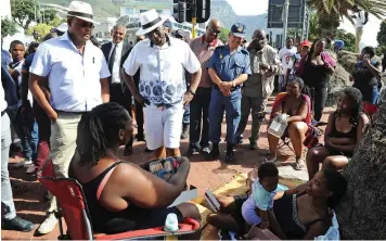  ?? COURTNEY AFRICA African News Agency (ANA) ?? MINISTER of Police Bheki Cele, right, accompanie­d by special adviser Lennit Max, engages with beachgoers at Camps Bay beach yesterday after the New Year's Eve festivitie­s. |