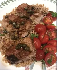  ??  ?? Pork Tenderloin Medallions With Balsamic Vinegar Pan Sauce are served atop rice with sliced cherry tomatoes.