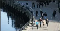  ?? JASON PAYNE/ PNG ?? People enjoy the sunshine and clear skies while walking along the seawall in Coal Harbour in Vancouver on Friday.