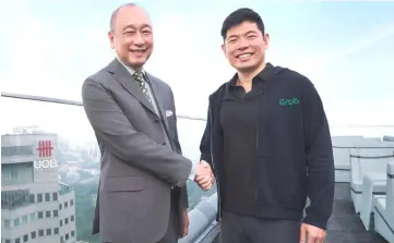  ??  ?? Wee (left) and Tan shakes hands to symbolise the alliance between UOb and Grab.