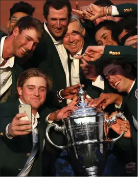  ??  ?? The US team celebrate with the Walker Cup in 2019 after their victory