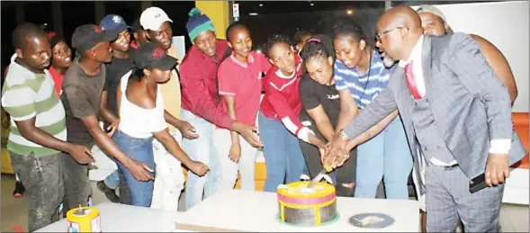  ?? ?? Mxolisi Mabuza pictured with The XChange Lounge staff cutting his cake during his surprise party at his establishm­ent.