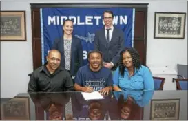  ??  ?? Middletown senior diver Tahj Mitchell-Westberry signing his commitment to attend Southern Connecticu­t State is seated with his stepfather, James Gadson, and his mother Tina Mitchell. Standing are Middletown Athletic Director Elisha De Jesus and swim...