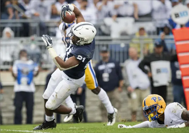  ?? Steph Chambers/Post-Gazette ?? Penn State’s Noah Cain beats Pitt’s Damar Hamlin to the end zone for the go-ahead — and ultimately winning — points in the third quarter Saturday in University Park, Pa.