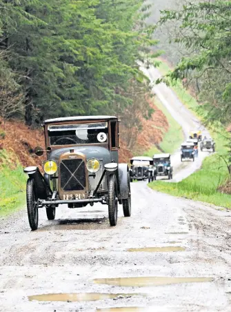  ?? ?? Front runners Richard and Annie Scaldwell brave wet conditions to lead a group of enthusiast­s in yesterday’s Vintage Light Car Welsh Tour in Crychan Forest near Landovery.