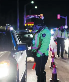  ?? JAMES PARK FOR NATIONAL POST ?? An Ottawa police officer conducts a RIDE check that screens for alcohol and cannabis on Thursday, the day after Canada legalized recreation­al marijuana use.