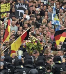  ??  ?? Protesters carry a wreath as they gather for a farright protest in Chemnitz, Germany, on Monday, after a man has died and two others were injured in an altercatio­n between several people of “various nationalit­ies” in the eastern German city of Chemnitz on Sunday. AP PHOTO/JENS MEYER