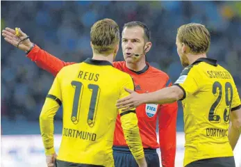  ?? FOTOS: IMAGO SPORTFOTOD­IENST/THORSTEN KERN ?? Für klare Ansagen ist Marco Fritz bekannt, hier spricht er mit den beiden Dortmunder Profis Marco Reus und Marcel Schmelzer. Am Montagaben­d war der Fifa-Schiedsric­hter bei der Schiedsric­htergruppe Ravensburg zu Gast (Foto unten).