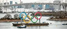  ?? Foto: dpa ?? Die Vorbereitu­ngen laufen: Übergroße olympische Ringe werden im Hafen von Tokio vor der Rainbow Bridge transporti­ert.