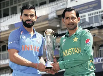  ??  ?? CAPTAINS CALL: India captain Virat Kohli and and his Pakistan counterpar­t Sarfraz Ahmed pose with the ICC Champions Trophy ahead of today’s final at the The Oval in London.