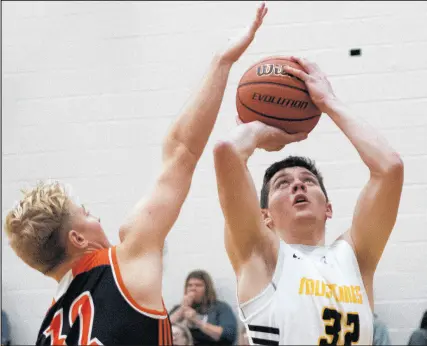  ?? MICHAEL GARD/POST-TRIBUNE ?? Kouts' Anthony Norman, right, takes a shot while being guarded by Westville's Elliot Bogart during the game on Friday.