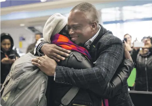  ?? ASHLEE REZIN GARCIA/ SUN- TIMES ?? Celestine Mugisha and his wife, Winniefred Akello, embrace at O’Hare Airport on Jan. 22, 2020, after living apart for more than three years. Mugisha and Akello were married in Uganda in September 2016.