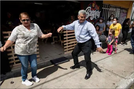  ?? AP PHOTO/MOISES CASTILLO ?? Fabio Rodolfo Vasquez dances with a customer at a promotiona­l event outside a coffee shop on the outskirts of Guatemala City on Sept. 19.