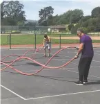  ??  ?? Rich Juarez (right) and college football player Hunter Juarez do a drill with a battle rope in Tiburon.