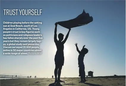  ?? Picture: AFP ?? Children playing before the setting sun at Seal Beach, south of Los Angeles in California, US. Young people’s trust in key figures such as politician­s and religious leaders has fallen sharply over the past five years but they remain largely happy, a...