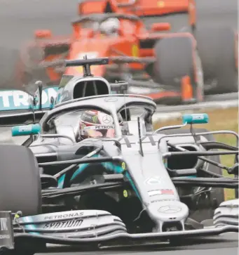  ?? LUCA BRUNO/ASSOCIATED PRESS ?? Mercedes driver Lewis Hamilton of Britain is followed by Ferrari driver Sebastian Vettel of Germany during practice Saturday at the racetrack in Silverston­e, England.