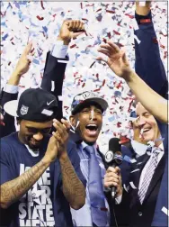  ?? David J. Phillip / Associated Press ?? UConn coach Kevin Ollie, center, celebrates with his team after their victory over Kentucky in the 2014 NCAA Tournament championsh­ip game.