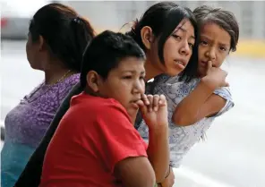  ??  ?? Fear: A family looks on as barbed wire is put up in McAllen, Texas