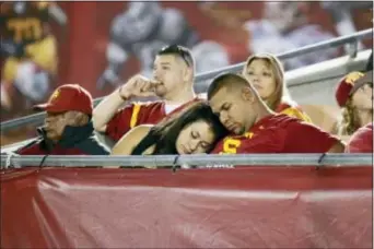  ?? DANNY MOLOSHOK — THE ASSOCIATED PRESS FILE ?? USC football fans fall asleep toward the end of a game against Arkansas State in 2015. The growing length of football games has the Pac-12 mulling ideas to shorten contests.