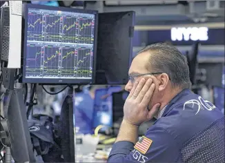  ?? RICHARDDRE­W/AP ?? Specialist Anthony Matesic works on the floor of the New York Stock Exchange in April. On a broad scope, this could be the least volatile year for stocks since 1964 if the current pace holds.