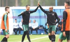  ??  ?? Ronaldo (second left) high fives with teammate midfielder Joao Mario during a training session of Portugal’s national football team at their base camp in Kratovo, outskirts of Moscow ahead of the Russia 2018 World Cup.