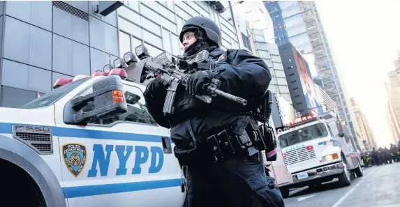  ?? Drew Angerer ?? > A police officer stands guard near the New York Port Authority Bus Terminal after the attempted terror attack