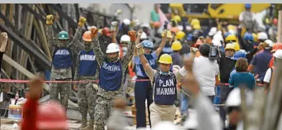  ?? —AP ?? SILENCE PLEASE Soldiers hold up closed fists motioning for silence so they can hear whoever might be buried in the rubble of the Enrique Rebsamen school in Mexico City after Tuesday’s 7.1-magnitude earthquake that killed more than 200 people.