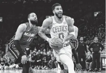  ?? BOB DECHIARA USA TODAY Sports ?? Celtics forward Jayson Tatum drives to the basket past Heat forward Caleb Martin in Game 1. With 59.4 seconds left, Martin was in pursuit of an offensive rebound and sent Tatum crashing to the court.