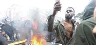  ?? AP ?? Un manifestan­te anti-Trump prende fuego ayer a un contenedor de basura en la calle K, en Washington.