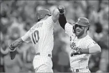  ?? MATT ROURKE/AP PHOTO ?? Philadelph­ia Phillies designated hitter Bryce Harper (3) celebrates his two-run home run with J.T. Realmuto (10) during the third inning in Game 3 of baseball’s National League Division Series against the Atlanta Braves on Friday in Philadelph­ia.