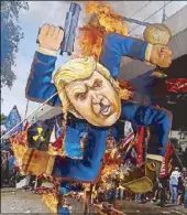  ?? MIGUEL DE GUZMAN ?? Militants burn an effigy of US President Donald Trump during a rally along Taft Avenue in Manila yesterday.